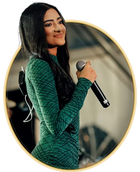 Chathurya Sandabarana singing on stage in a green gown